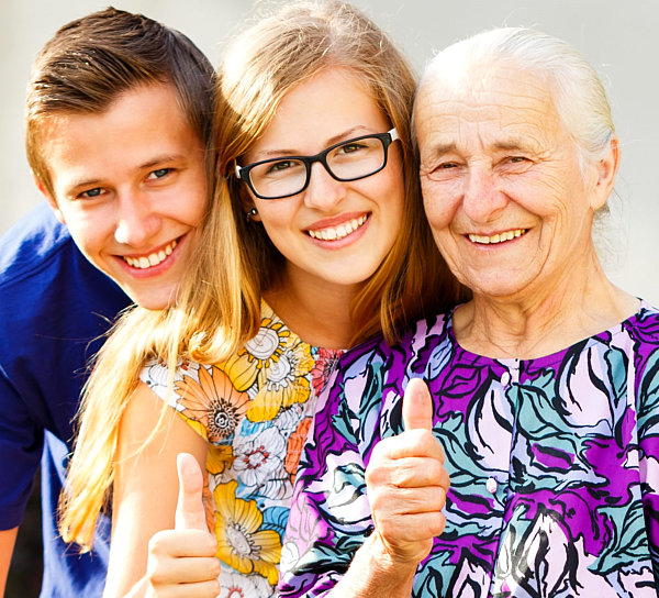 Kind grandmother showing thumbs up with grandchildren