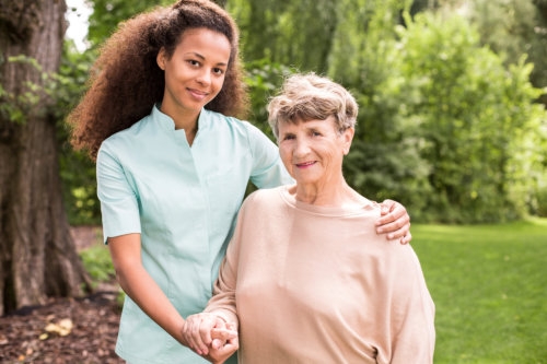 caregiver with an elderly woman, outdoors